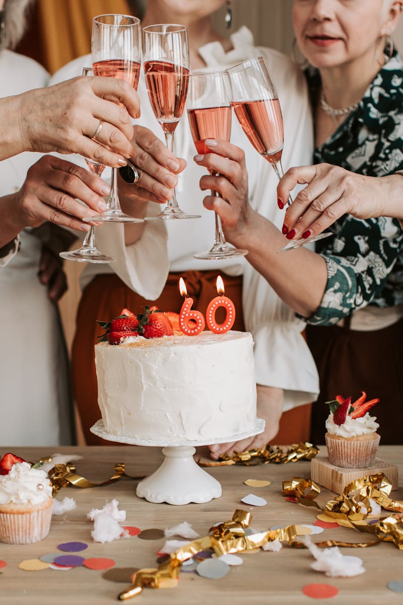 A lively 60th birthday celebration with friends toasting with champagne and enjoying cake.